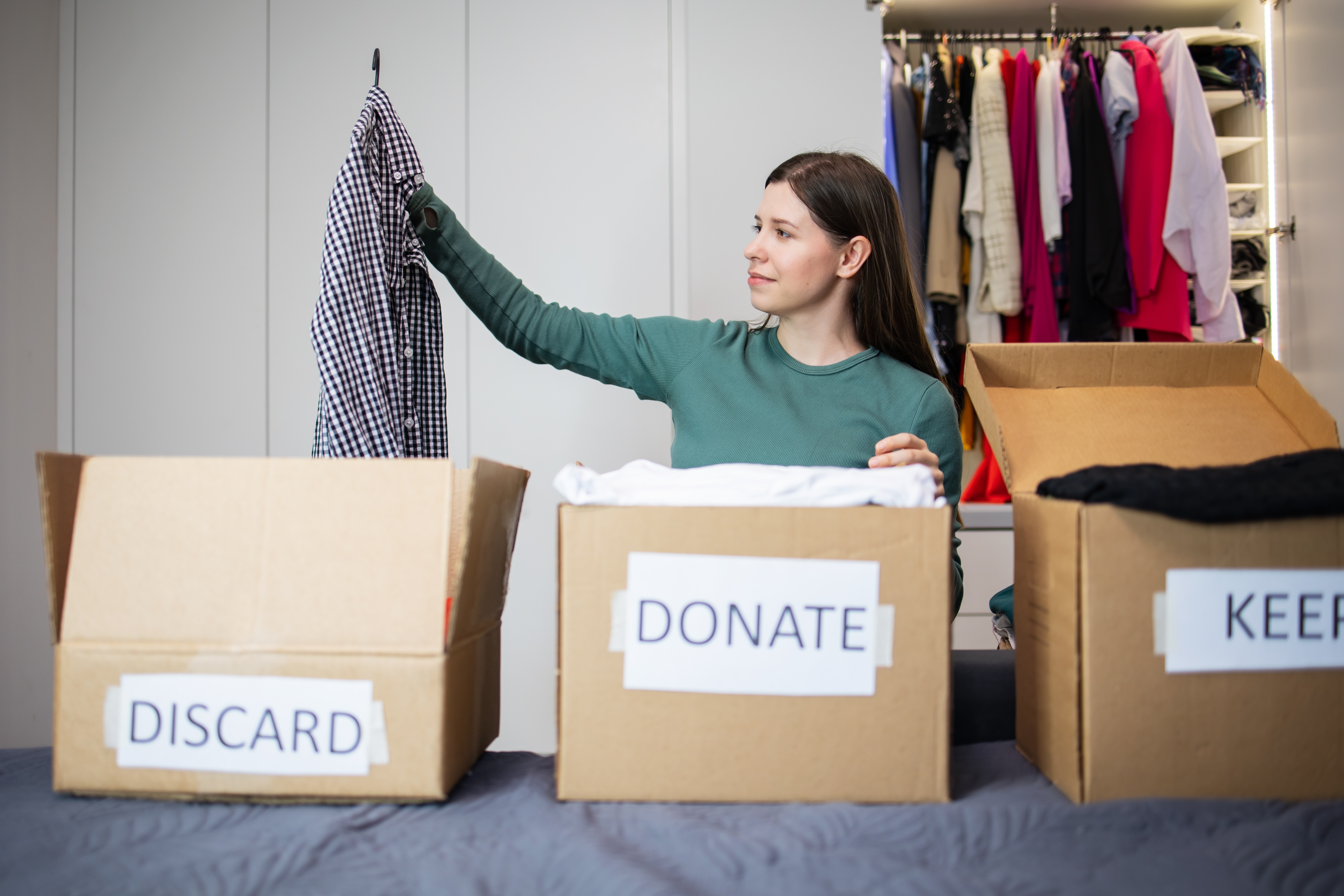 A woman sorting items in different boxes while decluttering A woman sorting items in different boxes while decluttering